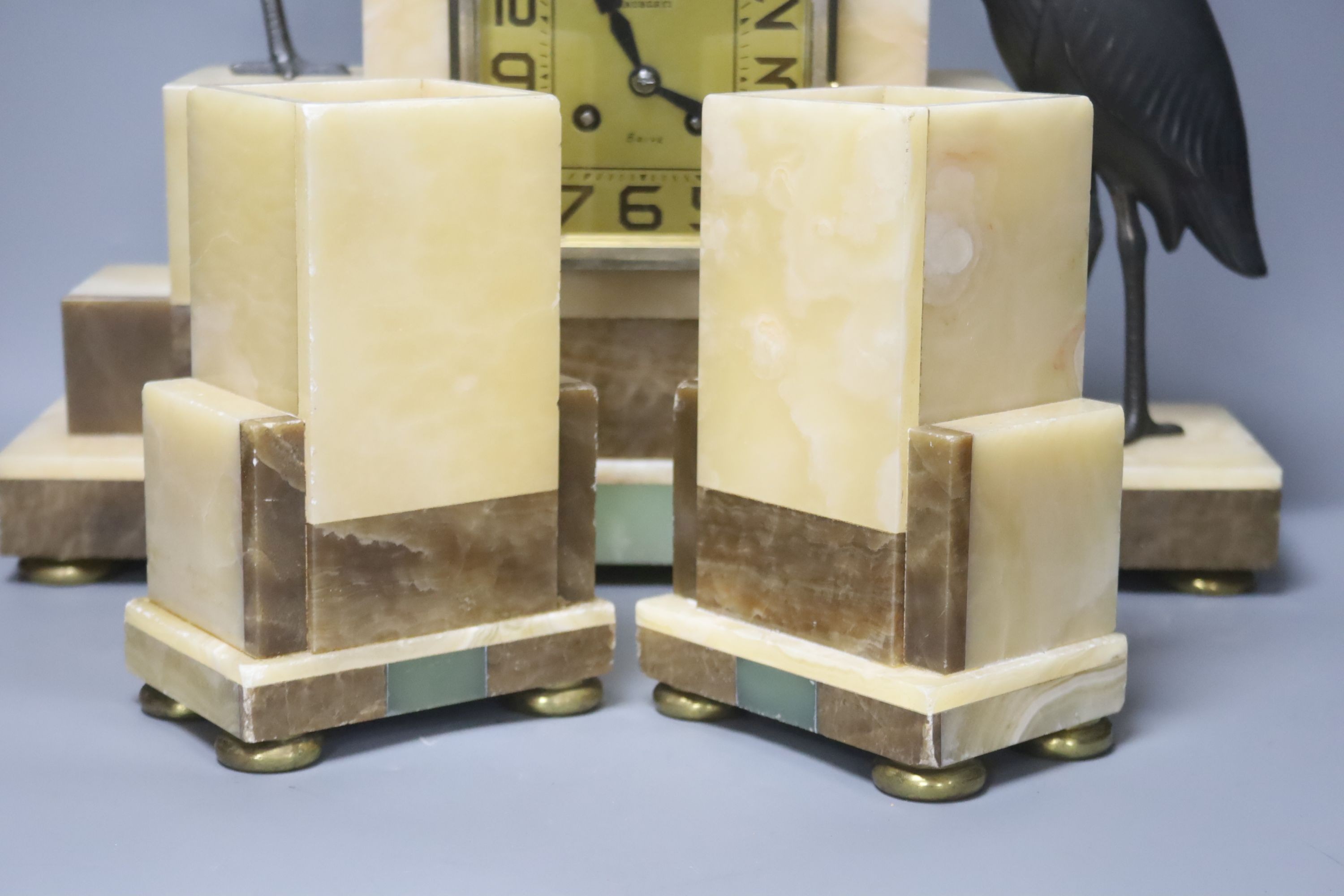 An Art Deco marble clock garniture clock surmounted with two spelter cranes, 42cm